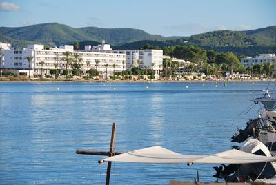 Scenic view of sea by buildings against sky