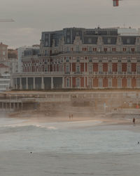 Buildings by sea against sky in city