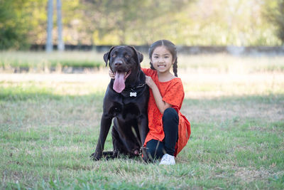 Portrait of dog sitting on field