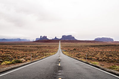 Empty road along countryside landscape