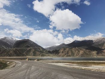 Road by mountains against sky