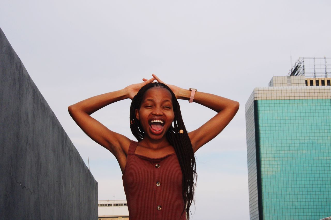 one person, front view, real people, standing, portrait, sky, lifestyles, mouth, young adult, looking at camera, leisure activity, mouth open, young women, emotion, happiness, architecture, day, built structure, shouting, swimming pool, outdoors, hairstyle, human arm