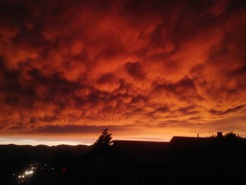 Silhouette landscape against dramatic sky during sunset