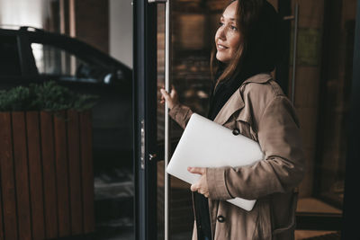 Woman looking away while standing on paper