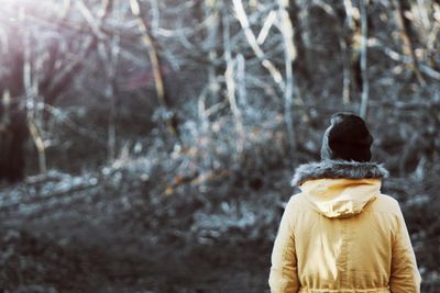 Rear view of woman in forest during winter