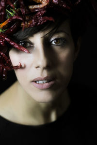 Close-up of young woman wearing red chili peppers