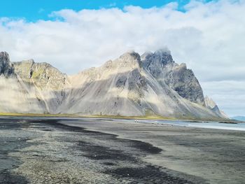 Scenic view of land and mountains against sky