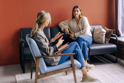 A psychotherapist consults and gives advice and psychological support to a young female patient.