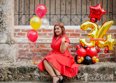 Portrait of a smiling young woman holding balloons