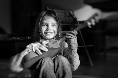 Portrait of smiling girl playing guitar