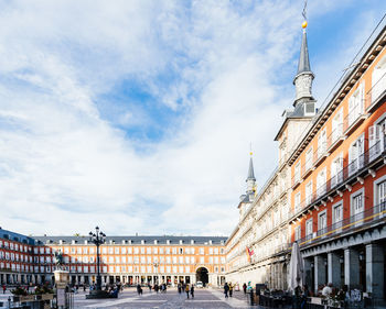 People on street against buildings in city