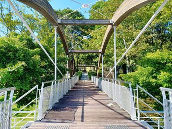 Low angle view of footbridge against trees