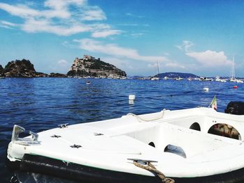 Sailboats moored on sea against sky