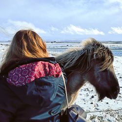 Rear view of woman in sea against sky