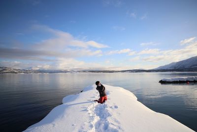 Woman in sea against sky