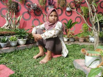 Portrait of young woman sitting in yard