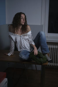 Young woman sitting on chair at home