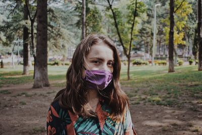 Portrait of young woman against tree