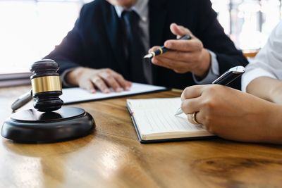 Midsection of woman holding mobile phone while sitting on table