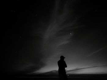 Silhouette man standing against sky at night