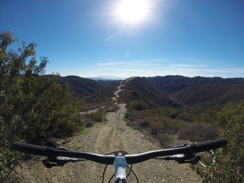 Cropped image of bicycle on mountain against sky