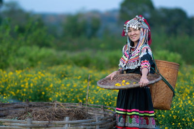 Full length of woman standing in basket on field