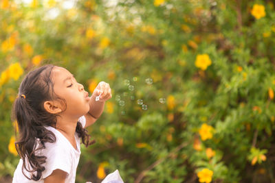 Side view of a girl looking away at plants