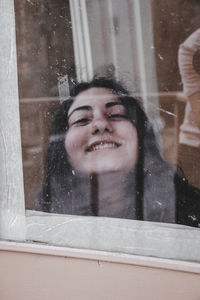 Portrait of a smiling young man in glass window