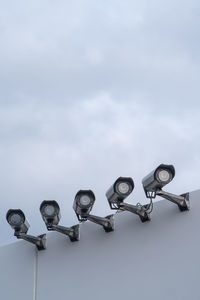 Low angle view of lighting equipment against sky