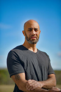 Mid adult man standing against blue sky