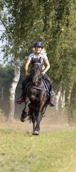 Young woman riding horse at park