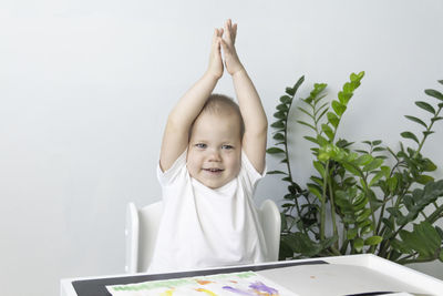 A small child draws a drawing with watercolors, develops and learns.