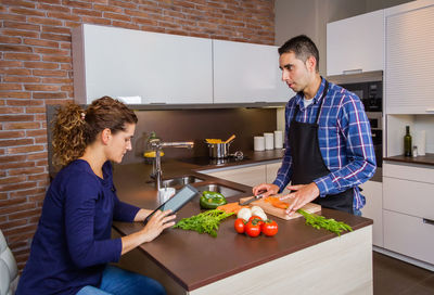 Young man preparing food in kitchen at home