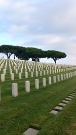 View of cemetery in field against sky