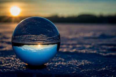 Close-up of crystal ball on beach