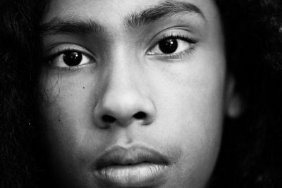 Close-up portrait of boy against black background