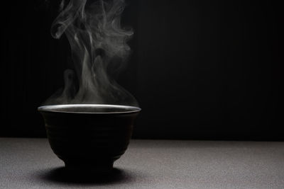 Close-up of tea served on table against black background