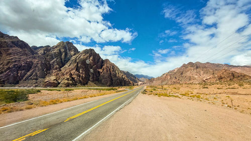 Road amidst mountains against sky
