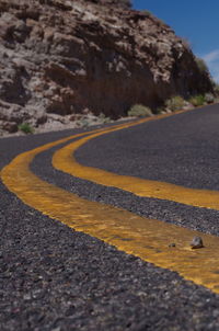 Road by mountain against sky