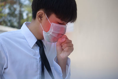 Teenage boy with mask against wall