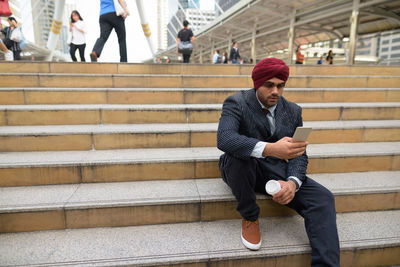 Full length of man sitting on staircase