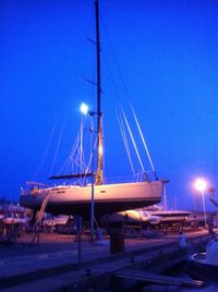 Sailboats moored at harbor