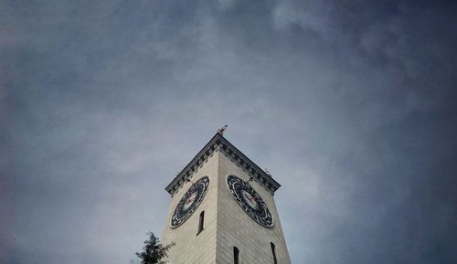 Low angle view of clock tower amidst building against sky