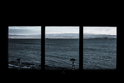 Scenic view of sea against sky seen through window