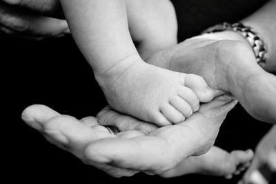 Cropped image of father holding son legs