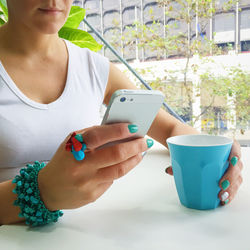Close-up of man holding coffee cup on table