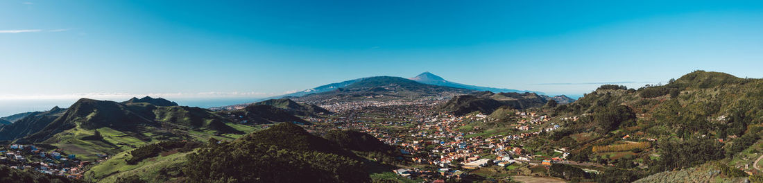 Panoramic view of mountains against clear blue sky