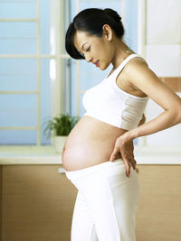 Side view of pregnant woman at home