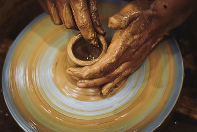 Close-up of hands working on pottery wheel