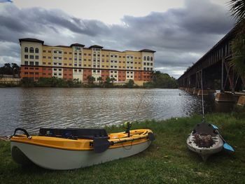 Boats in canal by city against sky